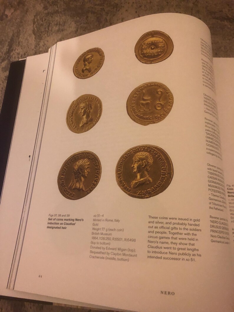 May include: Set of four gold coins featuring the profile of a Roman emperor. The coins are from the reign of Nero, the Roman emperor from 54 to 68 AD. The coins are 77 grams each and were minted in Rome, Italy. The coins are part of the British Museum collection.
