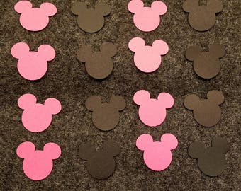 May include: A collection of pink and black paper cutouts shaped like Mickey Mouse heads.