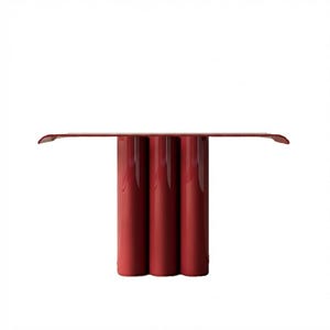 May include: A modern, red console table with a minimalist design. The table features a long, rectangular top supported by three cylindrical legs. The table's top extends slightly on either side. The table is approximately 60 inches long.