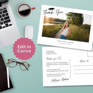 May include: Two graduation thank you cards with a photo of a graduate. The top card says "Thank You" with a graduation cap graphic. The bottom card has a handwritten message. A laptop, coffee cup, and glasses are also on the light blue surface.