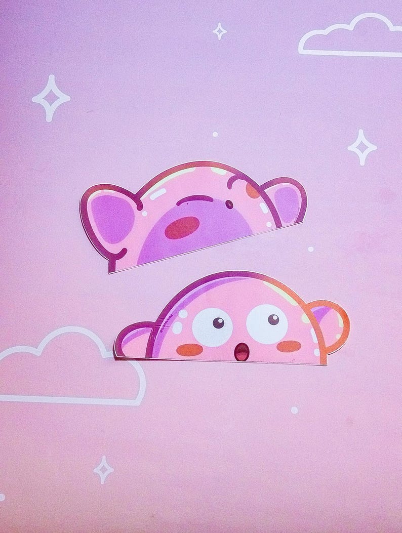 Puede incluir: Dos pegatinas rosas con personajes de dibujos animados con forma de oso. La pegatina superior tiene una expresi&oacute;n de ojos cerrados, mientras que la pegatina inferior tiene ojos grandes y la boca abierta. El fondo es un degradado rosa con formas de nubes y estrellas blancas.