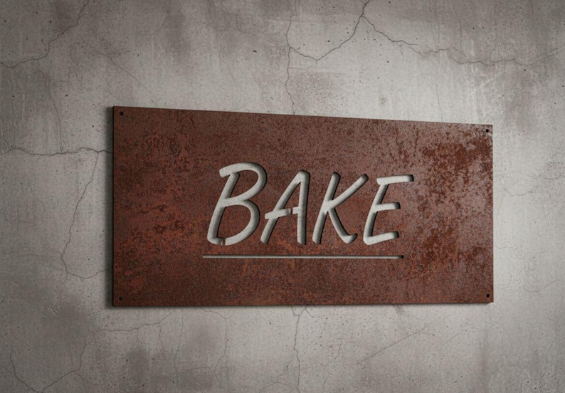 K&ouml;nnte beinhalten: Rechteckiges, rostbraunes Metallschild mit dem Wort "BAKE" in wei&szlig;en, stilisierten Buchstaben ausgeschnitten. Das Schild ist an einer strukturierten, grauen Betonwand angebracht, was auf ein K&uuml;chen- oder B&auml;ckereithema hindeutet.