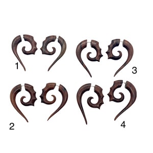 May include: Four pairs of wooden earrings with a spiral design. Each pair is numbered 1 through 4.