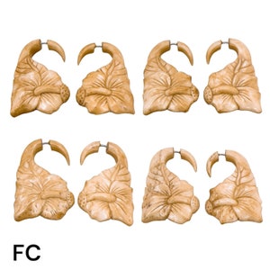 May include: Six pairs of carved wooden earrings in the shape of a flower. The earrings are a light brown colour and have a silver hoop.