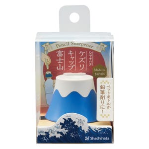 Puede incluir: Un sacapuntas de plástico azul y blanco con forma del monte Fuji, empaquetado en una caja transparente. El envase incluye texto en japonés, un gráfico del sacapuntas sobre una botella y un patrón de olas con el logotipo de Shachihata.
