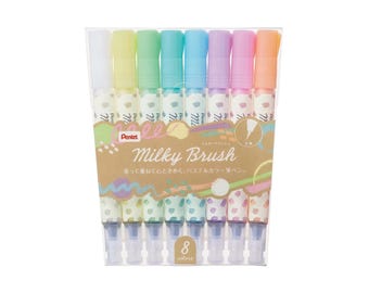May include: A set of eight pastel colored brush tip markers in a clear plastic package. The markers are labeled "Milky Brush" and feature a polka dot design. The package also includes the text "Brush Tip Markers".