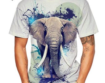 May include: Beige t-shirt featuring a detailed graphic of an elephant with large tusks. The elephant is centered on the shirt, with a blue and white abstract design around it. The word "Beige" is printed in the upper left corner.