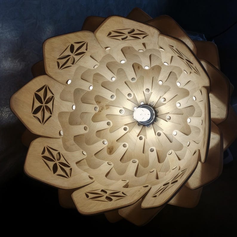 K&ouml;nnte beinhalten: Eine Holz-Pendelleuchte mit bl&uuml;tenf&ouml;rmigem Design. Die Leuchte besteht aus geschichtetem, hellfarbigem Holz mit dekorativen Ausschnitten. Die Gl&uuml;hbirne ist in der Mitte sichtbar, und die Leuchte ist an einem Kabel aufgeh&auml;ngt.