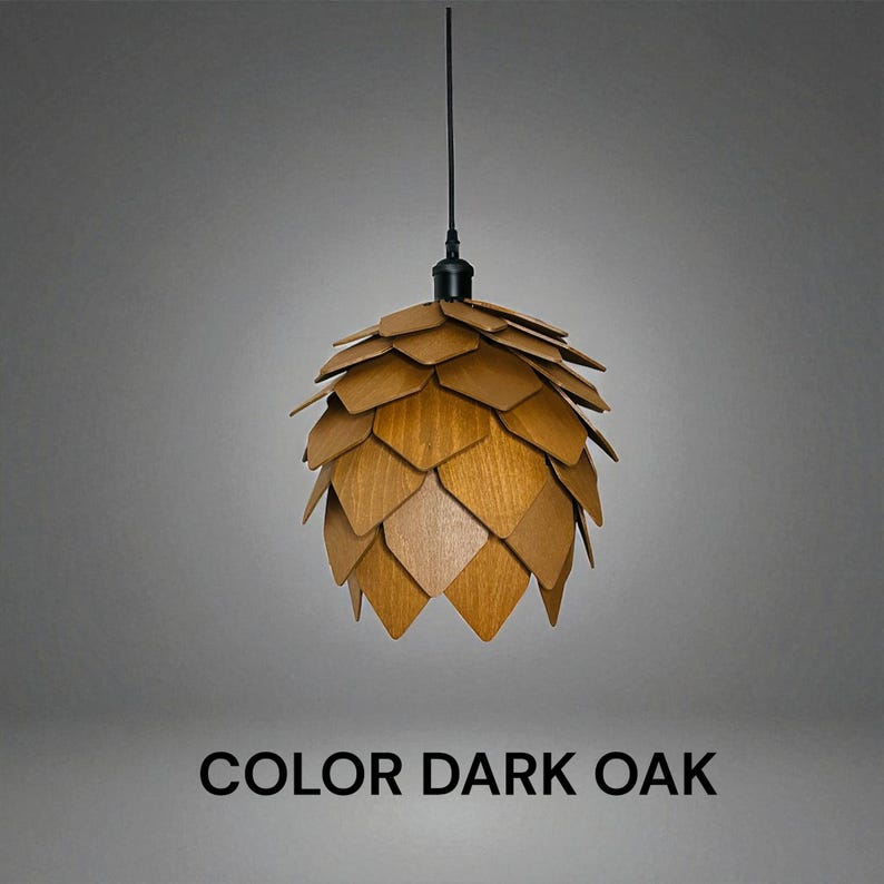 K&ouml;nnte beinhalten: H&auml;ngeleuchte in dunkler Eiche. Der Lampenschirm besteht aus &uuml;berlappenden Holzsegmenten, die ein geometrisches Muster bilden. Der Text "COLOR DARK OAK" ist darunter zu sehen.