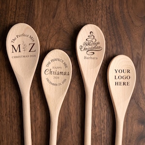 May include: Four light-colored wooden spoons with laser-engraved text and designs. The first reads The Perfect Mix M Z Christmas 2026, the second The Perfect Mix Happy Chrismas December 25, 2026, the third Merry Christmas Barbara, and the fourth Your Logo Here.