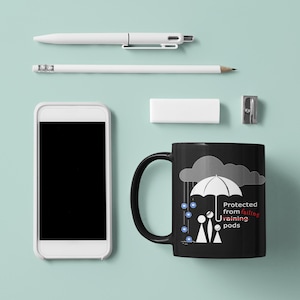 May include: Black coffee mug with a white illustration of two people standing under an umbrella with raindrops falling. The text on the mug reads "Protected from failing training pods".
