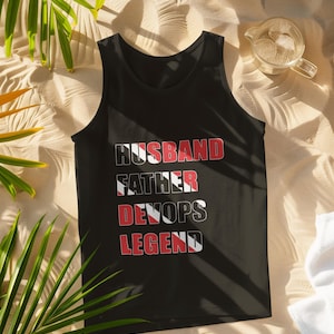 May include: Black tank top with the text "Husband Father DevOps Legend" in white with a red and black flag design.