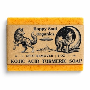 Puede incluir: Una pastilla de jabón rectangular de cúrcuma con una etiqueta de papel marrón. La etiqueta presenta ilustraciones de lobos, una montaña y una luna creciente. El texto de la etiqueta dice "Happy Soul Organics", "Spot Remover" y "Kojic Acid Turmeric Soap". El jabón pesa 113 gramos.