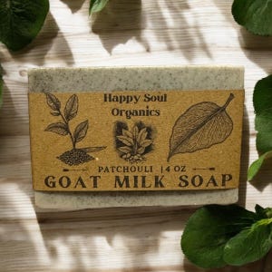May include: A bar of green goat milk soap with a brown label that reads "Happy Soul Organics Patchouli 1.4 oz Goat Milk Soap".