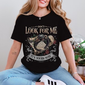 a woman sitting on a chair wearing a black shirt