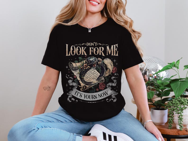 a woman sitting on a chair wearing a black shirt