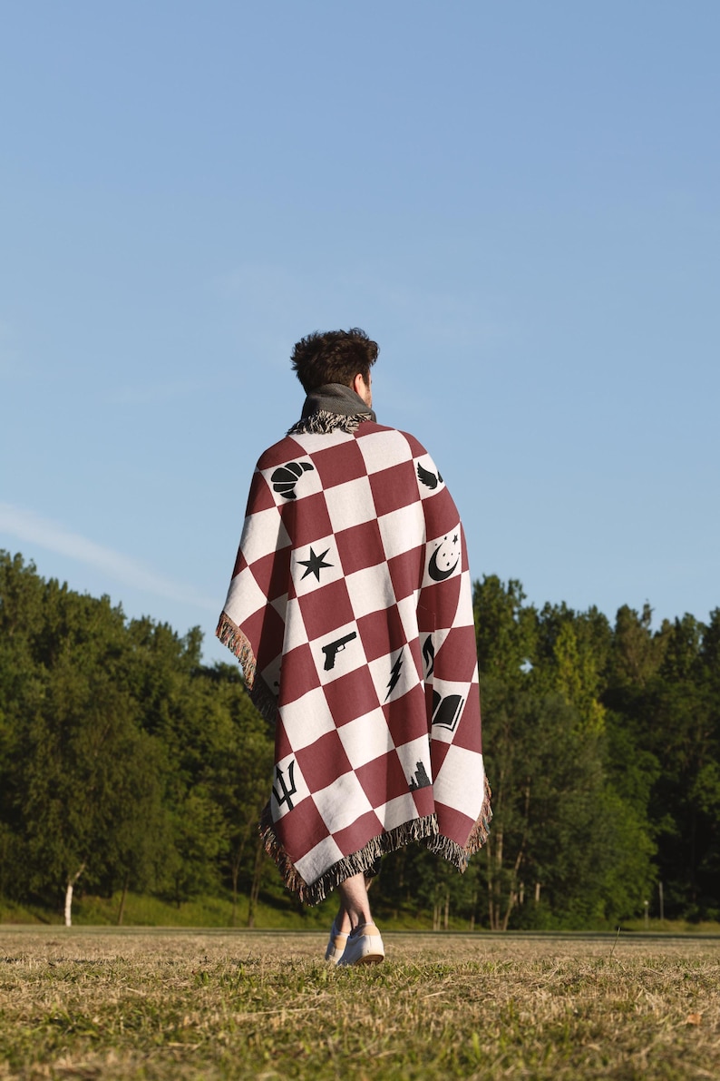 a person standing in a field with a blanket
