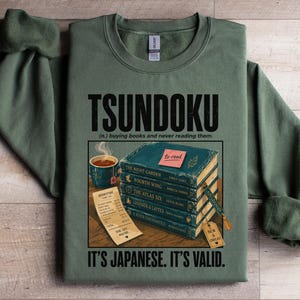 Green sweatshirt with "TSUNDOKU" text and stacked books with "to-read" label.