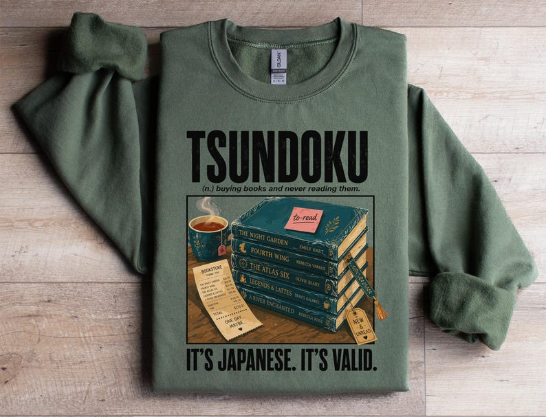 Green sweatshirt with "TSUNDOKU" text and stacked books with "to-read" label.