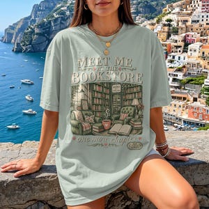 Mint green t-shirt with "Meet Me at the Bookstore" text and book-themed illustration.