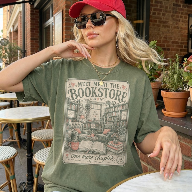 Woman wearing olive green t-shirt with bookstore illustration and text.