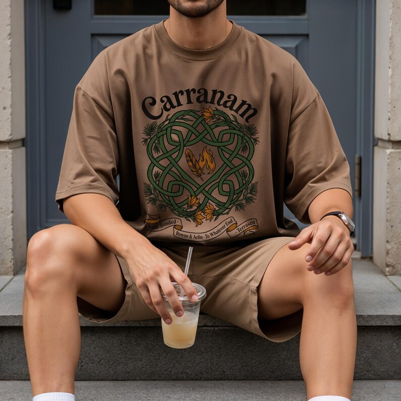 Brown t-shirt with Celtic knot design and text "Carranam" on a person.