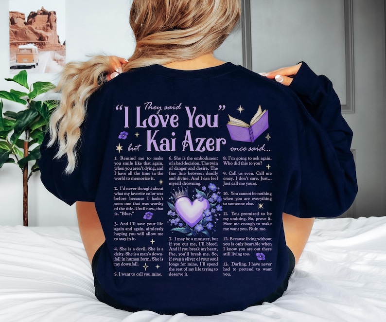 a woman sitting on a bed wearing a t - shirt that says i love you