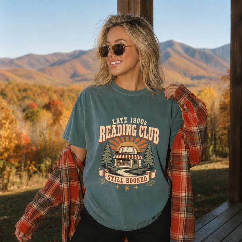 Teal t-shirt with "Late 1900s Reading Club Still Booked" graphic and plaid shirt.