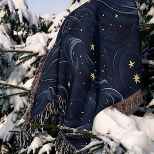a blanket sitting on top of a tree covered in snow