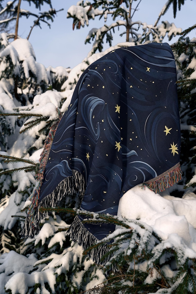 a blanket sitting on top of a tree covered in snow