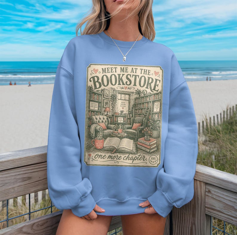 Light blue sweatshirt with "Meet me at the Bookstore" design and book-themed illustrations.