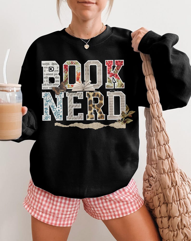 Black sweatshirt with "BOOK NERD" text in floral and distressed letter designs.