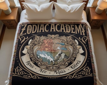 Könnte beinhalten: Schwarze gewebte Decke mit goldfarbenem Schriftzug "ZODIAC ACADEMY". Das zentrale Emblem zeigt Feuer, Luft, Wasser und Erde. Die Decke hat einen Fransenrand. Die Maße sind in Zentimetern.