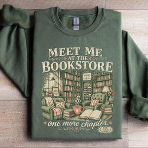 Green sweatshirt with "Meet Me At The Bookstore" and book-themed illustration.
