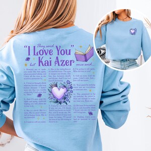 a woman wearing a blue sweatshirt with a book on it