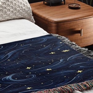 a bed with a night sky blanket on top of it
