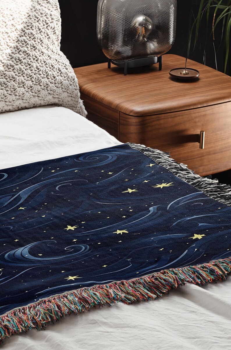 a bed with a night sky blanket on top of it