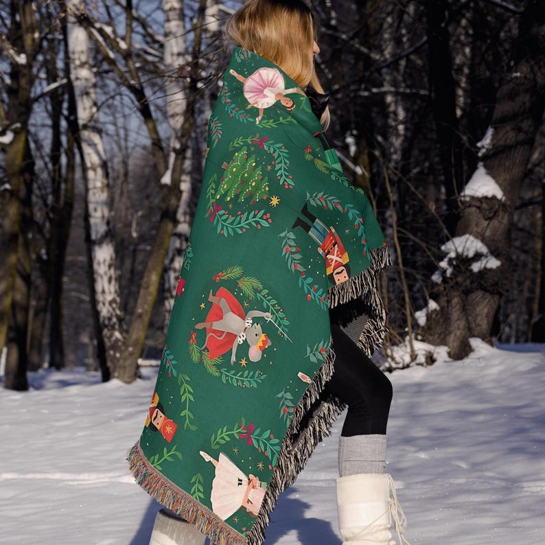 a woman walking in the snow carrying a blanket