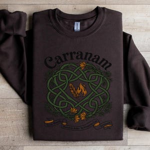 Brown sweatshirt with a Celtic knot design, featuring text "Carranam" and "Soul-Bonded Rowan & Aelin. To Whatever End Terrasen".