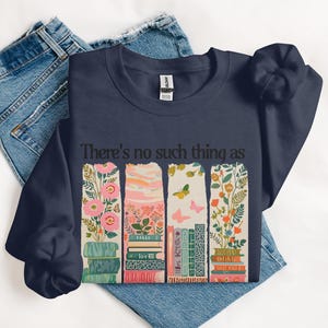 Navy sweatshirt with stacked books and floral design, text "There's no such thing as".