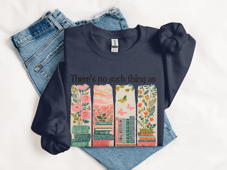 Navy sweatshirt with stacked books and floral design, text "There's no such thing as".