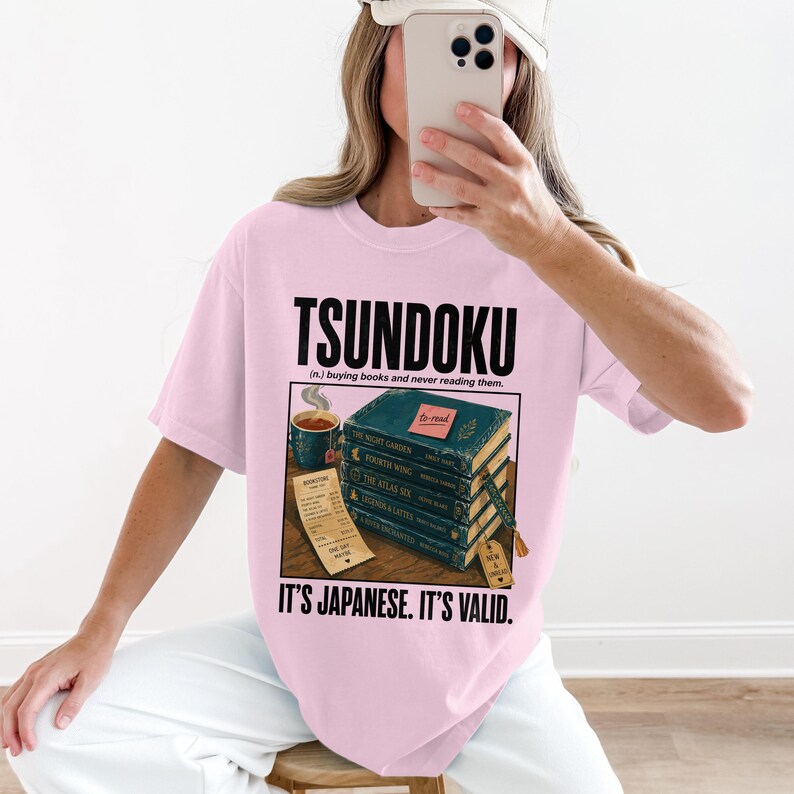 Pink t-shirt with "TSUNDOKU" and stack of books receipt.