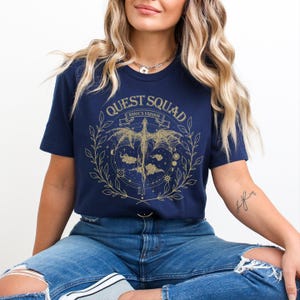 a woman wearing a blue shirt and ripped jeans