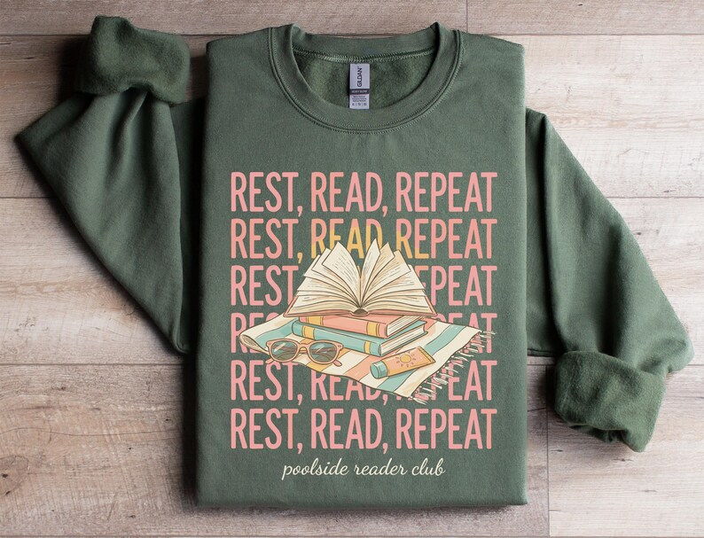 Green sweatshirt with "Rest, Read, Repeat" and "poolside reader club" text and illustrations.