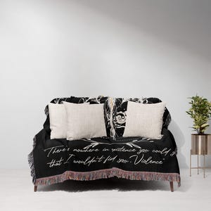a bed with a black and white comforter and pillows