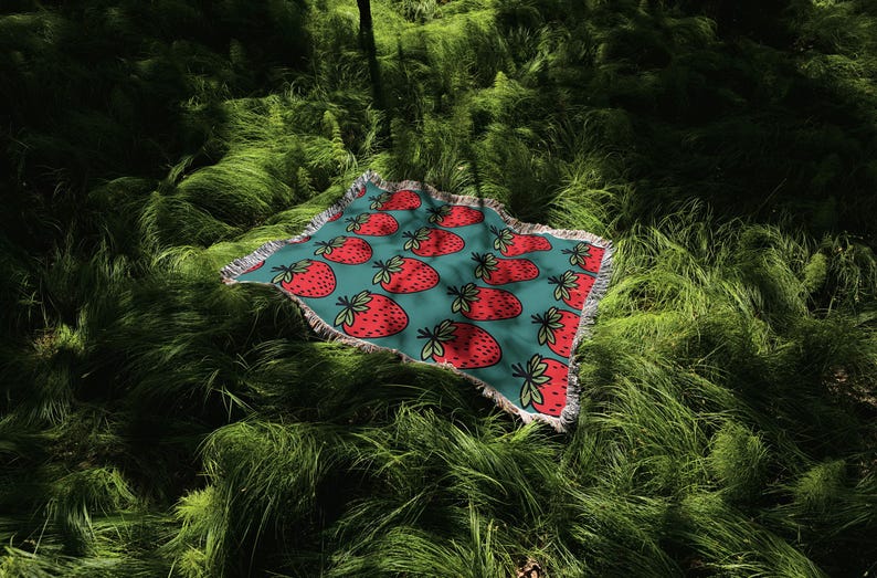 a red and blue umbrella sitting in the grass