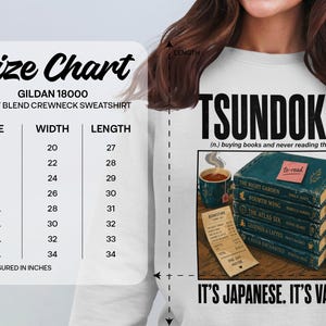 T-shirt size chart and graphic of stacked books titled "Tsundoku".