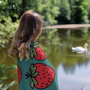 a young girl looking at a swan in a pond