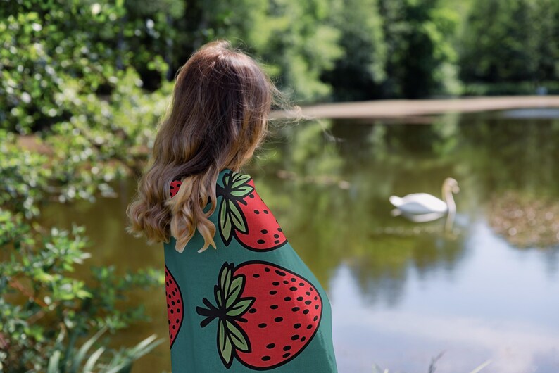 a young girl looking at a swan in a pond