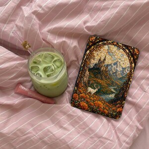 Phone case with stained glass art of castle, mountains, deer, and flowers.
